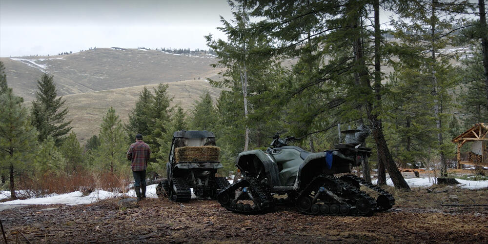 Camso Powersports ATV UTV track system vehicle working man trees mountains 1000x500